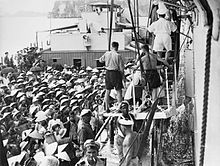 Refugees transfer from a French LCT landing craft to British carrier HMS Warrior at the port of Haiphong during the operation 4 September 1954 HMS Warrior 1954Saigon.jpg