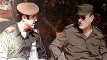 Ba'athist leader Hafez al-Assad alongside his brother Rifaat al-Assad at a military ceremony in Damascus, 1984 Hafez Assad rifaat Assad.jpg.webp