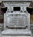 Reformationsdenkmal an der Südfassade der Hospitalkirche in Stuttgart, Sockel der Christusstatue mit Sarkophag, Symboldarstellungen der vier Evangelisten und einer Inschriftentafel.