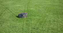 A robotic lawn mower with visible track marks in a lawn indicating the random way it cuts the grass Husqvarna Automower 308 with track marks in lawn.jpg