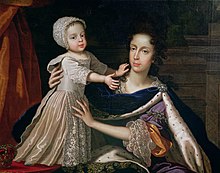 An informal portrait of Mary with her infant son. She is seated, wearing a regal velvet cloak edged with ermine. The boy, aged about one year, stands on a table and is held by his mother. He wears a cream satin dress with lace bonnet, sleeves and apron.