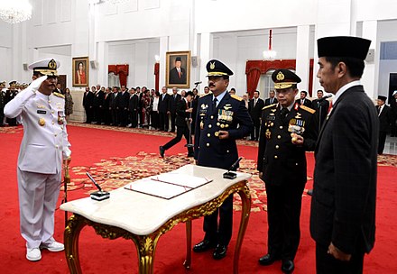 The Chief of Staff of the Indonesian Navy Admiral Siwi Sukma Adji salutes the President of Indonesia Joko Widodo.