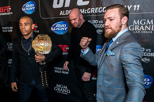 Conor McGregor, José Aldo, and Dana White at a press conference for the fight between McGregor and Aldo. This shows the two fighters posing for media,