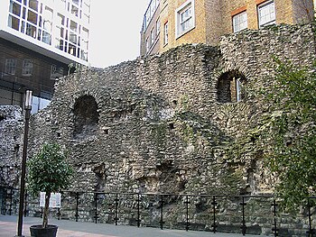 A surviving section of the London Wall behind Tower Hill tube station. A line of red Roman brick tiles can be seen near its base. London Wall fragment.jpg