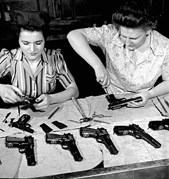 Dernier assemblage de pistolets 9 mm par deux ouvrières, pour expédition en Chine, avril 1944.