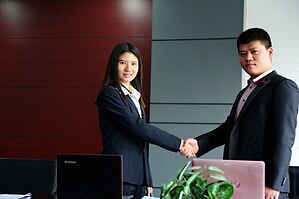 A professional woman is making a deal with her male client. This shows globalization has increased job opportunities for women in urban China. Professional woman.jpg