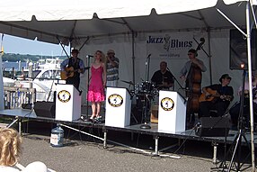 Juke Joint Johnny perform with Chelsea Palermo on the Riverfront Stage, June 2009; marina boats on the Navesink set the scene. RedBankJazzBluesFest2009r.jpg