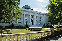 Mansion-looking library with pillars and two stone lions guarding the front entrance