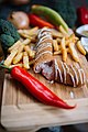 Serbian Karadjordje steak with cheese and french fries on wooden table in the restaurant. Closeup of pickle cheese. (49175391851).jpg