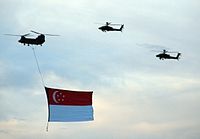 Гигантский флаг Сингапура, спущенный с вертолёта CH-47 Chinook во время репетиции парада 29-го июля 2006 года, когда играл «Majulah Singapura»
