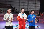 Deutsch: Tischtennis bei den Olympischen Jugend-Sommerspielen 2018: Tag 4, 10. Oktober 2018, Jungen-Einzel, Siegerehrung - Gold: Wang Chuqin (CHN), Silber: Tomokazu Harimoto (JPN), Bronze: Kanak Jha (USA); Medaillen überreicht durch IOC-Mitglied William Frederick Blick (UGA), Maskottchen überreicht durch ITTF-Präsident Thomas Weickert (GER) English: Fencing at the 2018 Summer Youth Olympics at 10 October 2018 –Boys' single medail ceremony – Gold: Wang Chuqin (CHN), Silber: Tomokazu Harimoto (JPN), Bronze: Kanak Jha (USA)); Medal presenter: IOC member William Frederick Blick (UGA), Mascot presenter: ITTF President Thomas Weickert (GER)