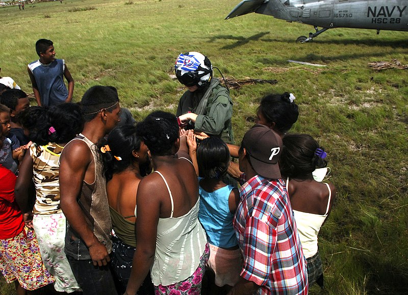 File:US Navy 070907-N-7540C-030 A U.S. Navy pilot hands out candy to local children while delivering food and water from the multipurpose amphibious assault ship USS Wasp (LHD 1).jpg