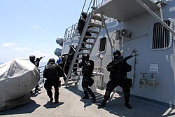 Anggota Pasukan Khusus Brunei bergegas menuju rumah pilot USS Howard (DDG-83) selama latihan kunjungan, naik kapal, penggeledahan dan penyitaan, Agustus 2008.