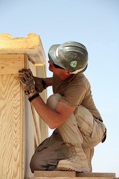 File:US Navy 081006-N-9623R-202 Builder 1st Class Scott Taylor works finishing the roof section on a South West Asia hut.jpg