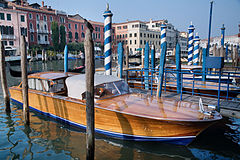 A wooden classic motorboat in the Grand Canal by the Rialto Bridge. Venice, Italy 2009