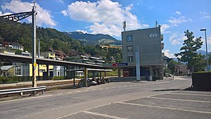 Edificio rectangular de cuatro pisos junto a plataformas cubiertas por dosel