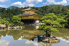 Water reflection of Kinkaku-ji Temple with a tree on a rock in the pond, Kyoto, Japan.jpg