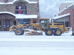 Caterpillar 143H grader plowing snow in Ouray,...
