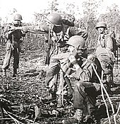 Noemfoor, Dutch New Guinea, July 1944. A US soldier (foreground) uses a Handie-Talkie during the Battle of Noemfoor. AWM 017402 Noemfoor radio.jpg