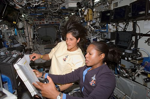 Joan Higginbotham and Williams work the controls of the Canadarm2 in the ISS's Destiny Laboratory