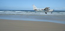 Flugzeug beim Start auf dem als Fluglandepiste genutzten Strand