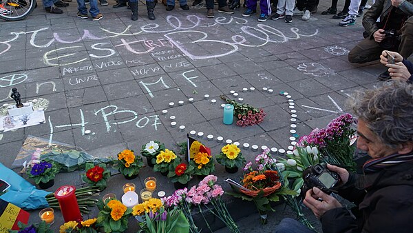 People gathering, chalk drawings and flowers for the victims. The largest message says (translated from French), Brussels is beautiful, with further i