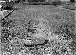 Tête sculptée dans la pierre dans un jardin à Pagar Alam (1931)