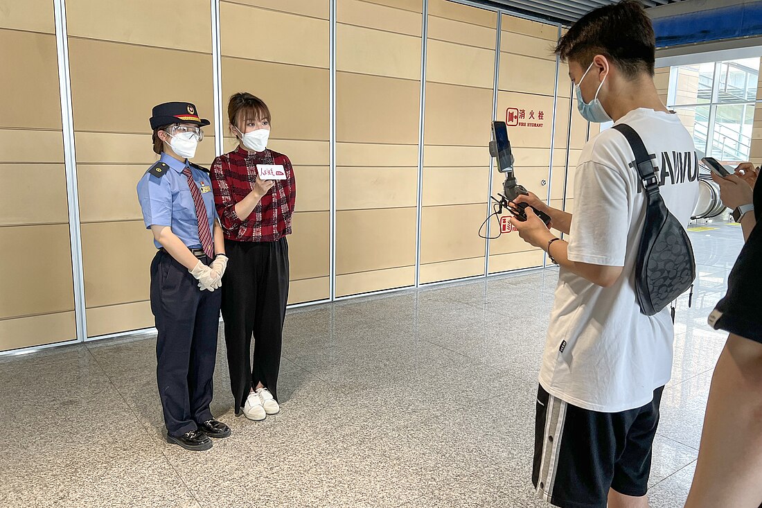 File:CR staff and PeopleRail journalist livestreaming at Beijing Fengtai Railway Station Exit 5 (20220620132147).jpg