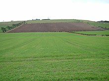 The western side of the battlefield of Flodden, looking south-south-east towards Branxton Hill. The Scottish army advanced down the ploughed field, the English down the grassy field in the foreground. The modern boundary between the two fields marks the position of the marsh encountered by the Scots Flodden Field (Braxton) - 2004-Feb-06 - Looking SSE from the monument.jpg
