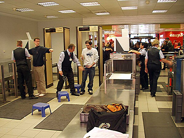 X-ray machines and metal detectors are used to control what is allowed to pass through an airport security perimeter.