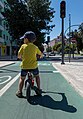 Image 889Gabriel on a balance bike waiting at a traffic stop, Praça de Londres, Lisbon, Portugal