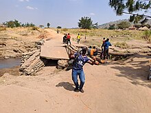 Happy man after crossing a broken down Bridge in Paidha Zombo