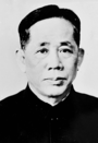 A young man, in a suit with a pale shirt and dark tie