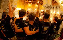 The moment of the Marriage Equality Act vote in balcony of the capital building in Albany, New York, the evening of July 24, 2011 photographed by Celebration Chapel of Kingston, NY. Persons in foreground are wearing t-shirts bearing the logo of the Human Rights Campaign, one of many organizations backing the bill. Marriage Equality Act vote in Albany NY on the evening of July 24, 2011 photographed by the Celebration Chapel of Kingston NY.jpg