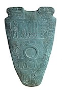 Reverso de la Paleta de Narmer, hacia el 3100 aC. La fila superior representa a cuatro hombres que llevan estándares. Sobre ellos es un Serej que contiene el nombre del rey, Narmer