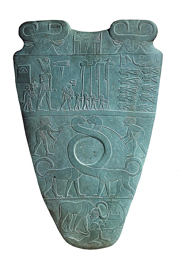 Reverse of the Narmer Palette, circa 3100 BC. The top row depicts four men carrying standards. Directly above them is a serekh containing the name of 