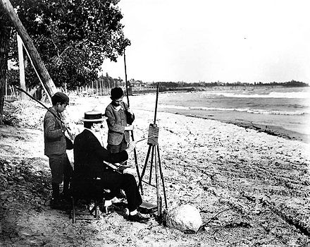 Owen Staples painting on the beach, 1907