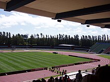 photo prise d'une tribune assise d'une piste d’athlétisme.