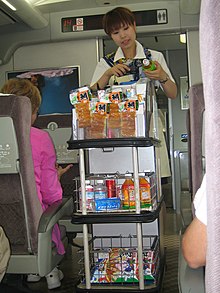 Snack vendor on the Shinkansen train scans a barcode. Snack vendor on the Shinkansen. 2005 (26321781190).jpg