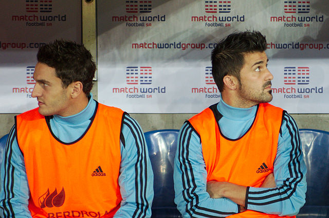 Koke (left) on the bench with Atlético teammate David Villa, in a friendly with Chile in 2013