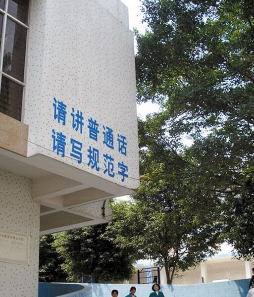 A school in Guangdong with writing "Please speak Standard Chinese. Please write standard characters" on the wall.