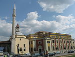 בניין עיריית טירנה (Bashkia) מימין, ומסגד אטהם ביי יחד עם מגדל השעון, משמאל