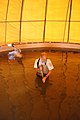 USFWS biologist cleans circular fish rearing pool of sediment (6106635488).jpg