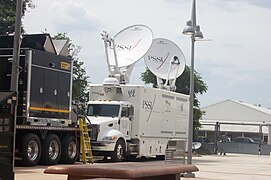 A WWE HD satellite truck in a parking lot.