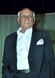 Photograph of Yash Chopra standing and looking to his left.