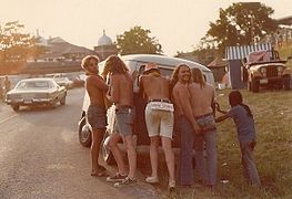 Jóvenes de estética hippie empujando una furgoneta Volkswagen de camino a un festival de música, Estados Unidos, 1974.]]