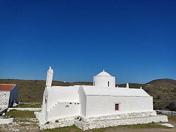 Στην εικόνα φαίνεται η δυτική πλευρά του ναού. Ο ναός είναι λευκός, ο ουρανός είναι μπλε, το χορτάρι πράσινο και πίσω από την εκκλησία υπάρχουν μικροί λόφοι.