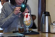 A restaurant patron taking a photo of their dessert Cang Fu San Zhai Shang Dian  (13993323591).jpg