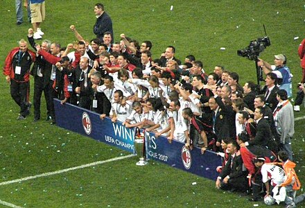 Milan players celebrate with the trophy.