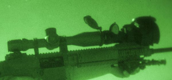 A standard telescopic sight augmented with a night-vision device in front on the M110. Note that in addition to the image intensifier, the NVD gathers